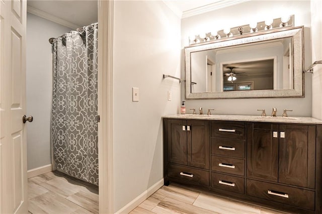 bathroom featuring a sink, double vanity, baseboards, and crown molding