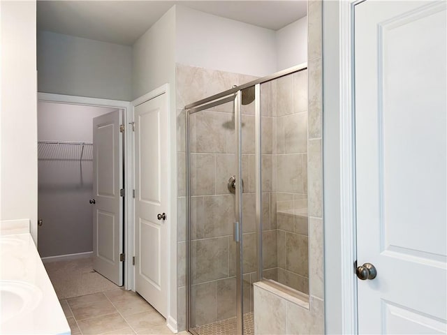 bathroom with tile patterned floors, a shower with door, and vanity