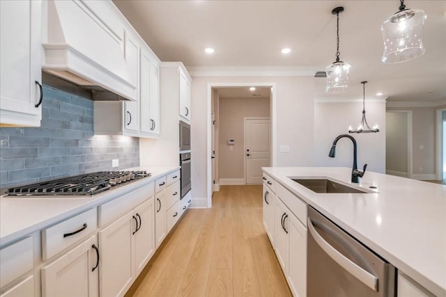 kitchen featuring sink, stainless steel appliances, hanging light fixtures, and premium range hood