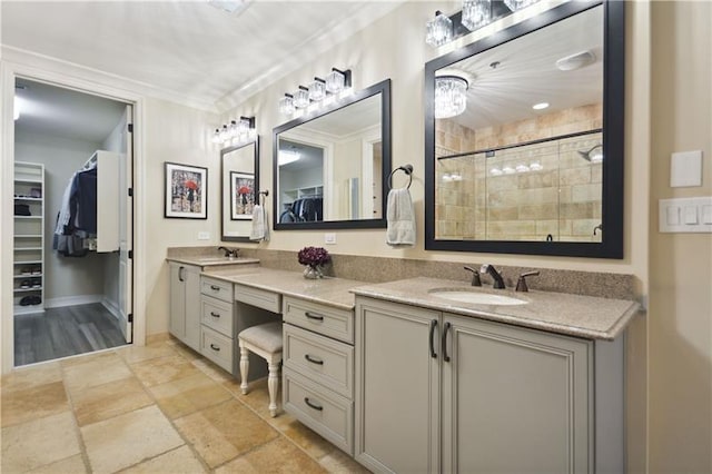 bathroom with ornamental molding, vanity, and a shower with door