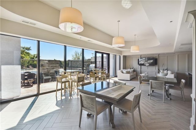 dining room featuring parquet flooring and a raised ceiling