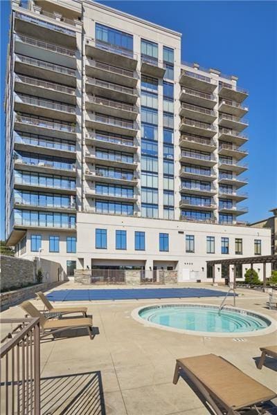 view of swimming pool with a patio area and a hot tub