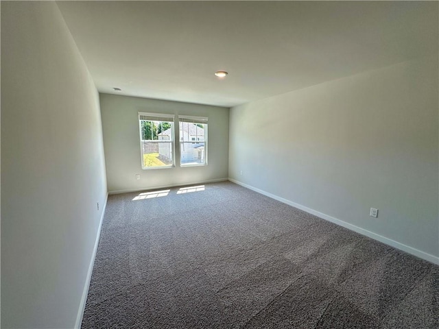 spare room featuring carpet floors and baseboards