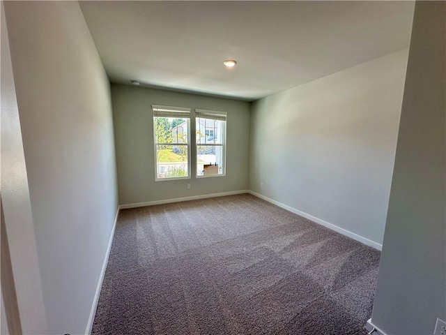 carpeted spare room featuring baseboards