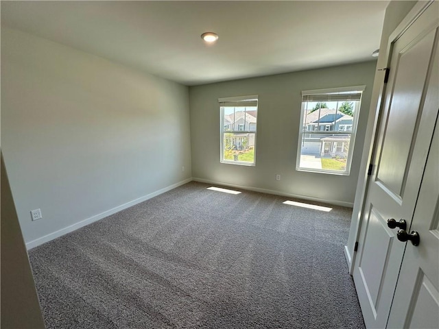 unfurnished room with carpet floors and baseboards