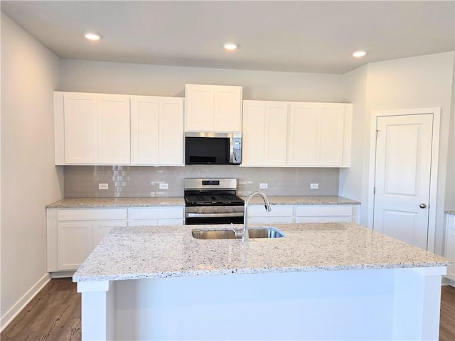 kitchen featuring dark wood-style floors, appliances with stainless steel finishes, a sink, and tasteful backsplash