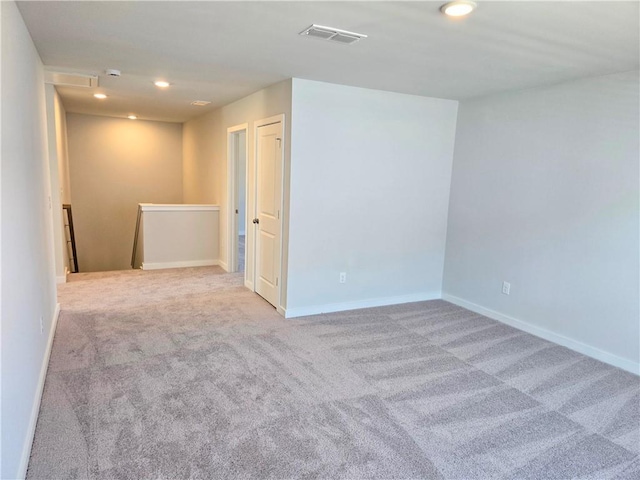 empty room with carpet floors, baseboards, visible vents, and recessed lighting