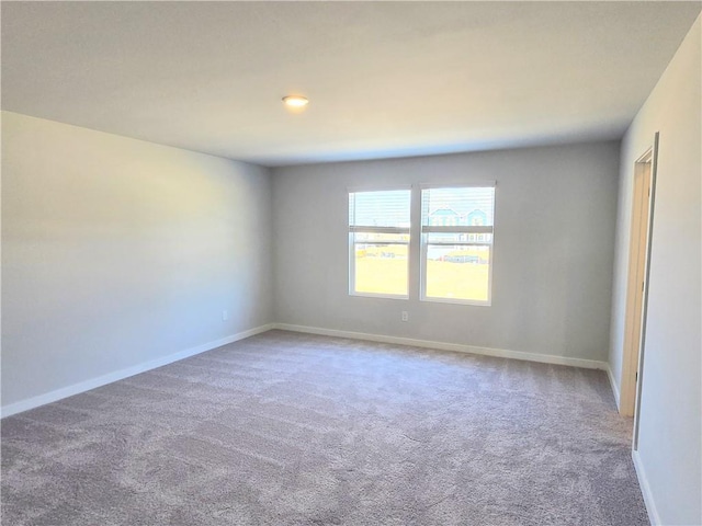 carpeted spare room with baseboards