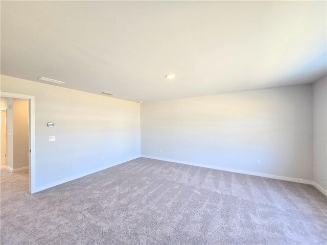 spare room featuring baseboards, visible vents, and carpet flooring