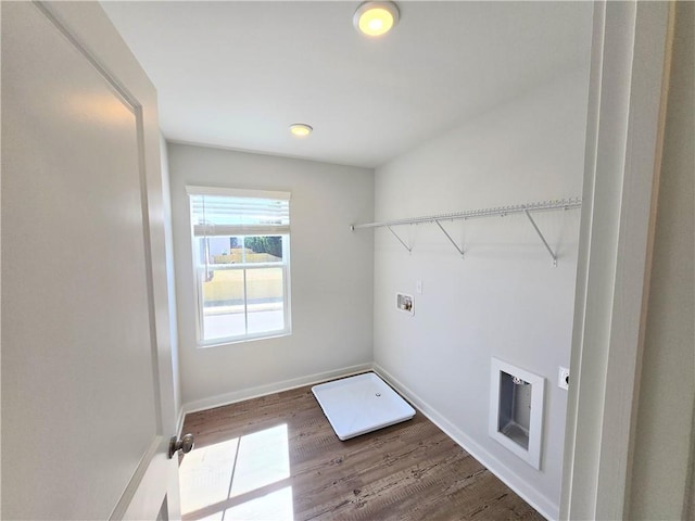 laundry area with laundry area, baseboards, washer hookup, and wood finished floors