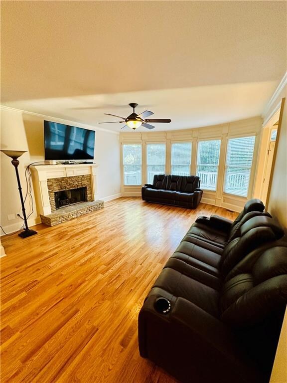 living room with ceiling fan, a fireplace, and hardwood / wood-style floors