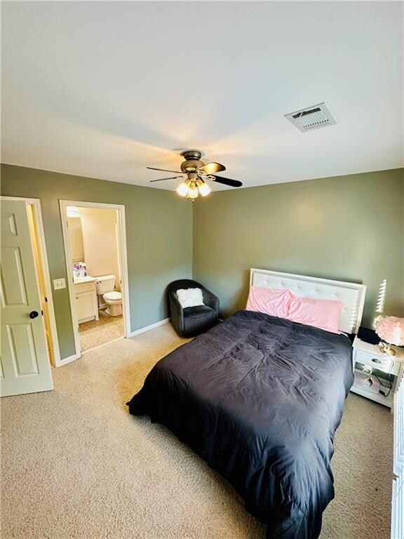 carpeted bedroom with connected bathroom and ceiling fan