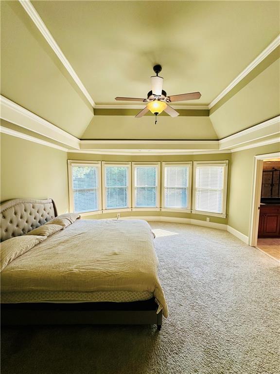 bedroom featuring ceiling fan, crown molding, vaulted ceiling, and multiple windows