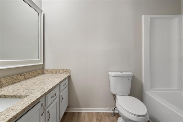 full bath with toilet, vanity, baseboards, and wood finished floors