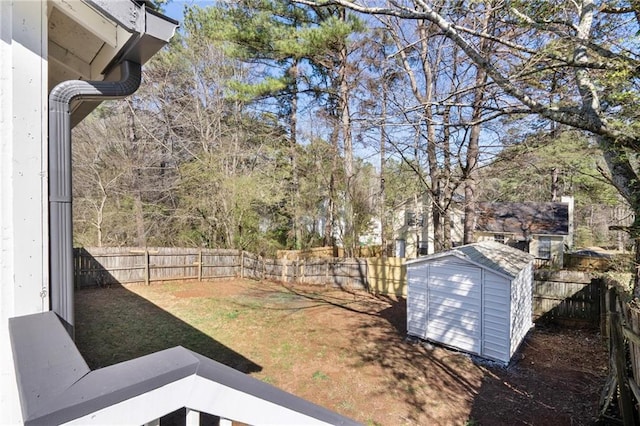 view of yard featuring a storage shed, an outbuilding, and a fenced backyard