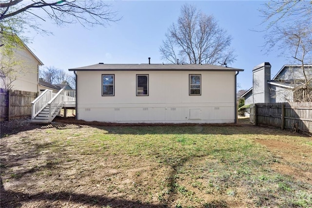 rear view of property featuring crawl space, a lawn, a fenced backyard, and stairs