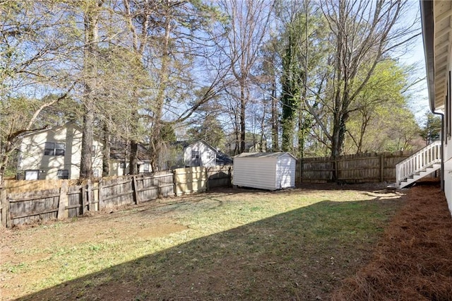 view of yard featuring an outbuilding, a fenced backyard, and a shed