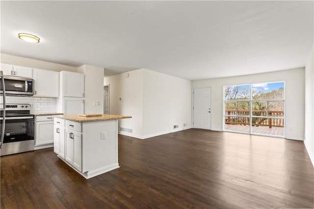 kitchen featuring tasteful backsplash, visible vents, open floor plan, a center island, and stainless steel appliances