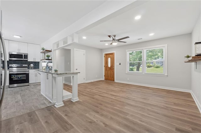2060 Panstone Ct SW, Marietta, GA 30060 - kitchen with stainless steel appliances, open shelves, white cabinetry, a breakfast bar, and a ceiling fan