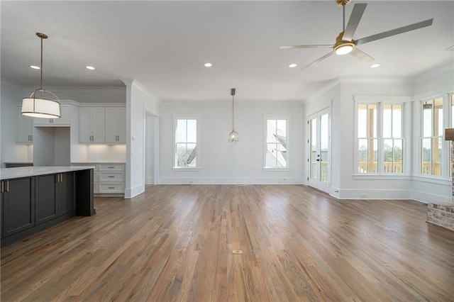 unfurnished living room featuring wood finished floors and ornamental molding