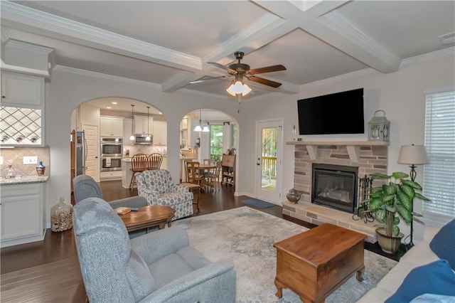 living room with dark hardwood / wood-style floors, a fireplace, coffered ceiling, crown molding, and beam ceiling