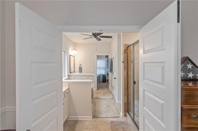 bathroom featuring a shower with door, vanity, tile patterned flooring, and ceiling fan