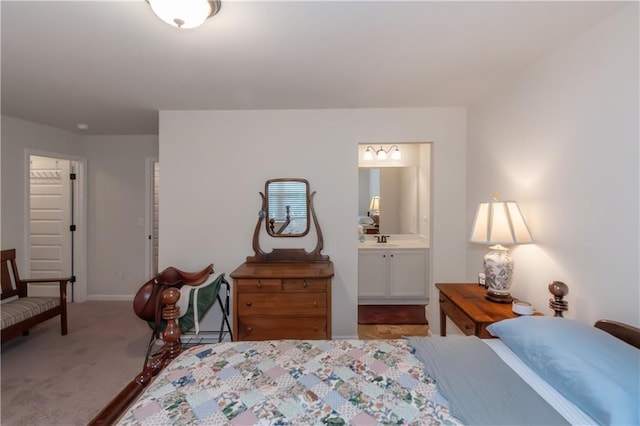 carpeted bedroom featuring connected bathroom and sink