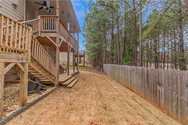 view of yard with a deck and ceiling fan