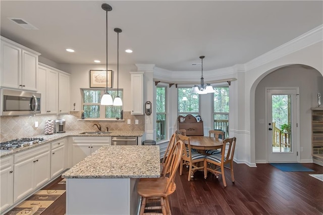 kitchen with stainless steel appliances, a center island, and white cabinets