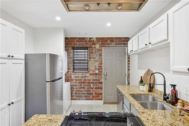 kitchen featuring white cabinetry, brick wall, appliances with stainless steel finishes, and sink