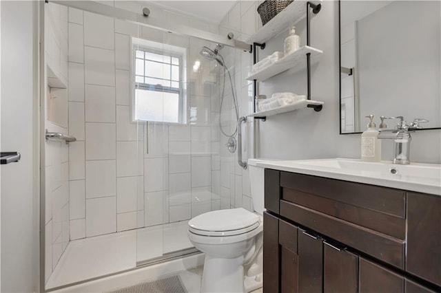 bathroom with vanity, toilet, and a shower with door