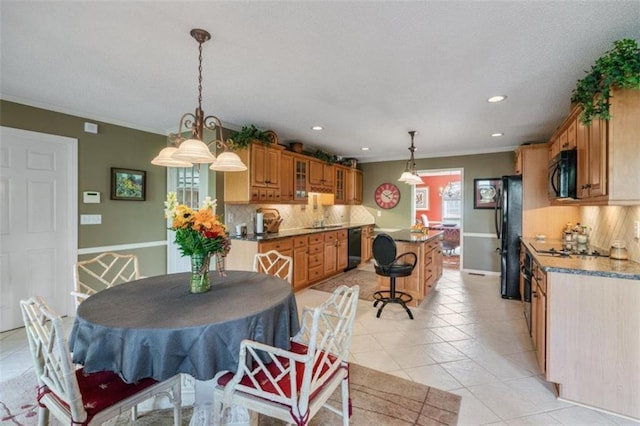 dining space featuring sink, crown molding, and light tile patterned flooring