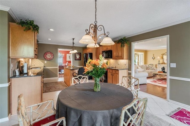 tiled dining room featuring ornamental molding and a textured ceiling