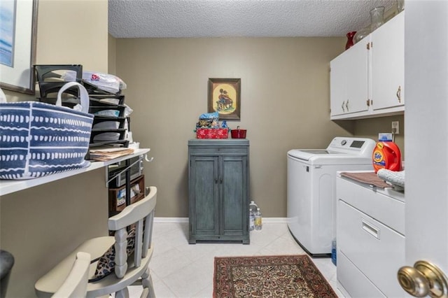 washroom with cabinets, separate washer and dryer, light tile patterned floors, and a textured ceiling