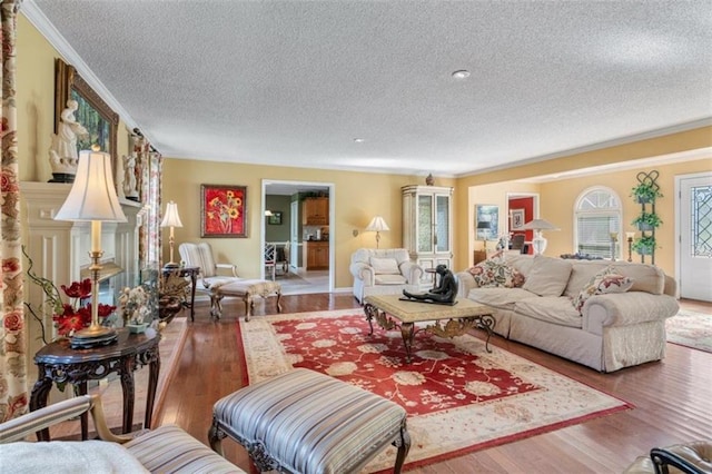 living room with wood-type flooring, crown molding, and a textured ceiling