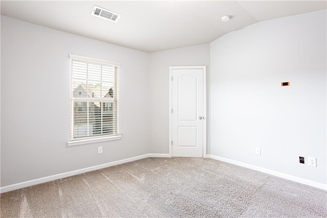 empty room with carpet flooring and vaulted ceiling