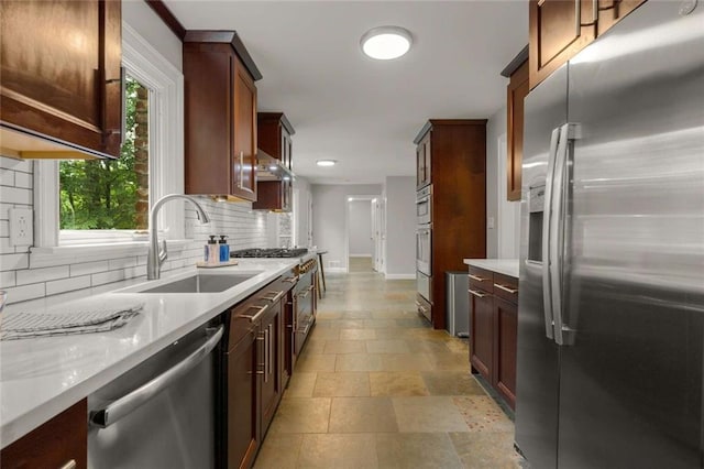 2892 Guinevere Dr NE, Atlanta, GA 30345 - kitchen featuring stainless steel appliances, a sink, decorative backsplash, baseboards, and light stone finish floors