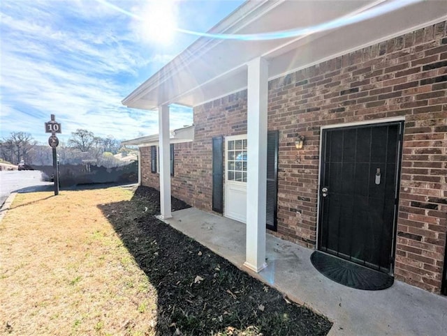 view of exterior entry featuring brick siding