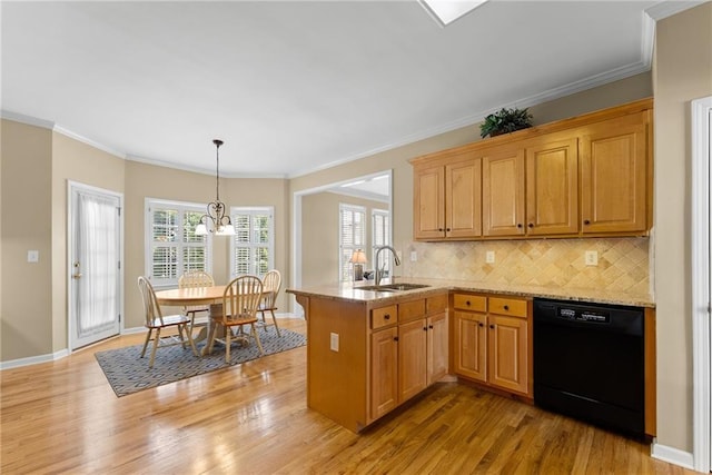 kitchen with black dishwasher, decorative backsplash, a sink, light wood-type flooring, and a peninsula