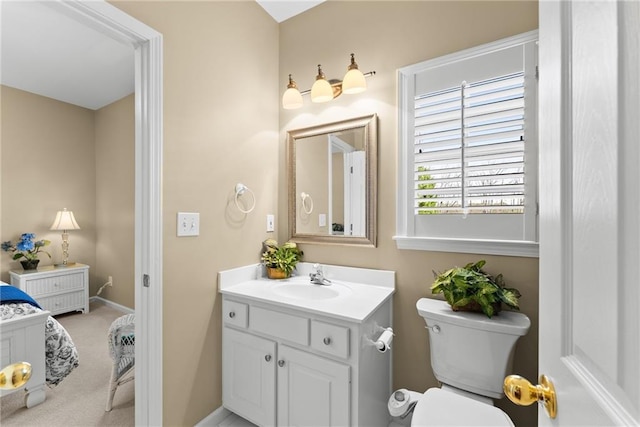 bathroom with toilet, baseboards, and vanity