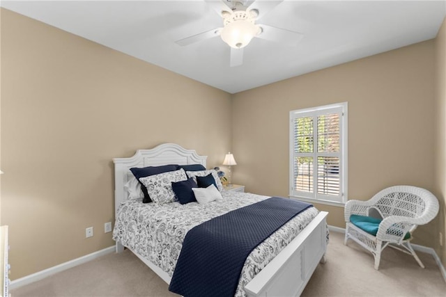 bedroom with a ceiling fan, light colored carpet, and baseboards