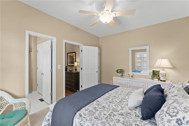 bedroom with light tile patterned floors, ceiling fan, and connected bathroom