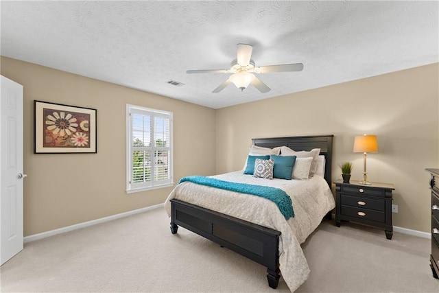 bedroom with light colored carpet, visible vents, a ceiling fan, a textured ceiling, and baseboards