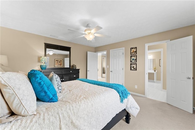 bedroom featuring ensuite bathroom, ceiling fan, visible vents, baseboards, and carpet