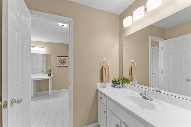 bathroom featuring tile patterned flooring, baseboards, and vanity