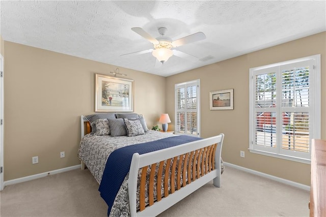 bedroom with carpet floors, a ceiling fan, baseboards, and a textured ceiling