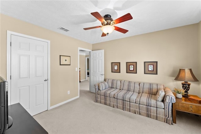 carpeted living room with ceiling fan, visible vents, and baseboards