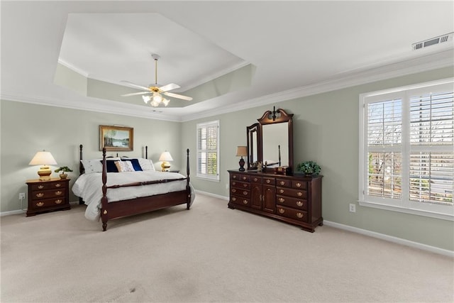 bedroom featuring crown molding, baseboards, a raised ceiling, and light colored carpet