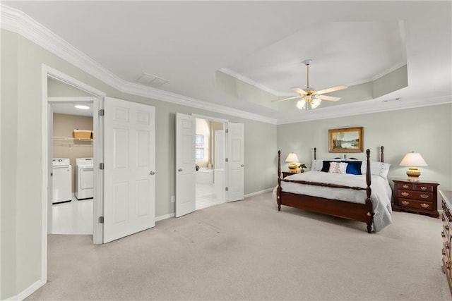 carpeted bedroom featuring ornamental molding, a tray ceiling, independent washer and dryer, and baseboards