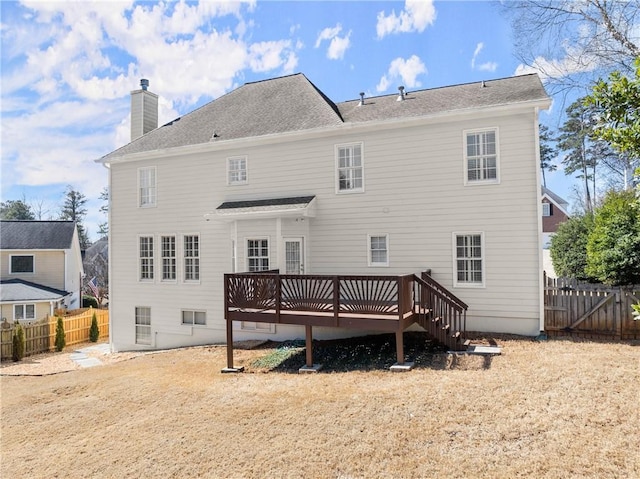 rear view of house with a fenced backyard, a chimney, and a deck